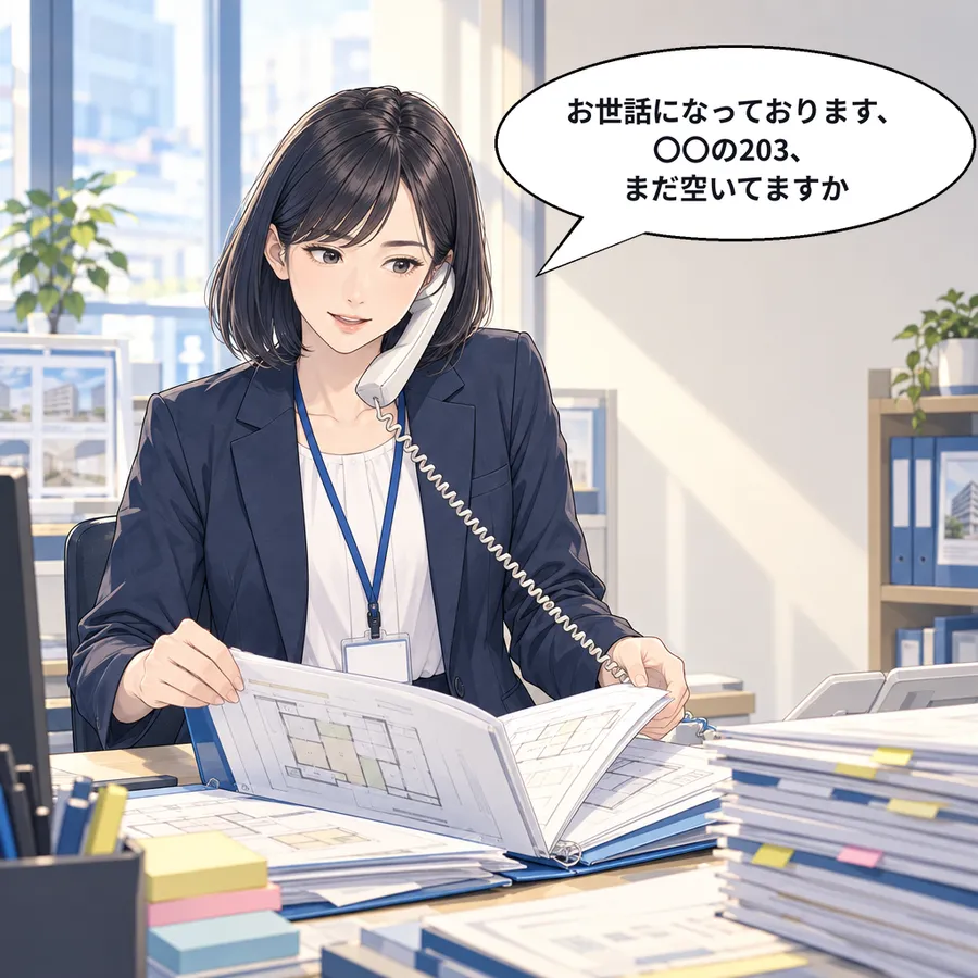 受話器を肩にはさみ、物件の資料をめくりながら電話する森さん